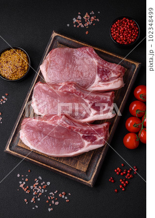 Raw pork on the bone or rib sliced with salt, spices and herbs Raw pork on the bone or rib sliced with salt, spices and herbs 102348499