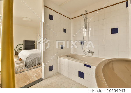 a bathroom with white tiles and blue trim around the tub, sink, and mirror in it's corner a bathroom with white tiles and blue trim around the tub, sink, and mirror in it's corner 102349454