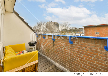 an outside area with a couch, chair and brick wall that has been painted to look like it's made out of bricks an outside area with a couch, chair and brick wall that has been painted to look like it's made out of bricks 102349456