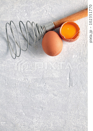 Two beige chicken eggs and a rare beater for beating Two beige chicken eggs and a rare beater for beating 102351770