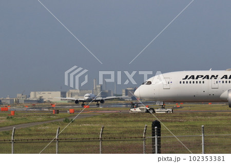 駐機場に牽引される旅客機　滑走路の横断を待機する旅客機 102353381