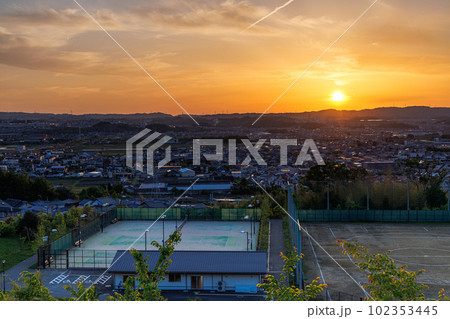 京都城山台夕景から夜景へ(マジックアワー)　山際まで沈んだ太陽に照らされ黄金色に輝く空と山城の地 102353445