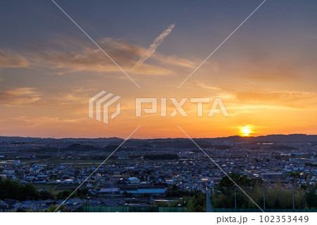 京都城山台夕景から夜景へ(マジックアワー)　山際へ沈んで行こうとする夕日と夕焼け空のグラデーション 102353449