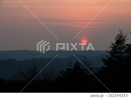 夏のの夕暮れ時、シルエットの山並みと真っ赤な太陽とのコラボレーションが綺麗だ。 102354253