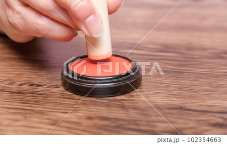 【判子に朱肉をつける女性】 102354663