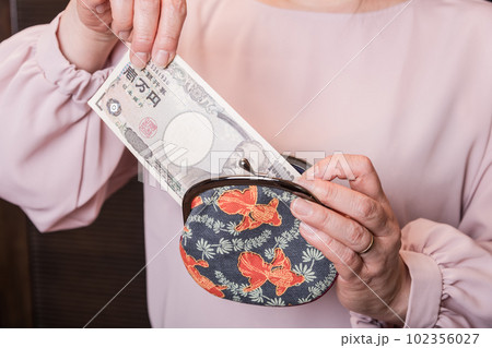 【がま口から10000円札を出す主婦】 【がま口から10000円札を出す主婦】 102356027