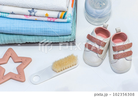 Baby girl pink shoes with other newborn baby accessories on white surface. Baby concept 102356308