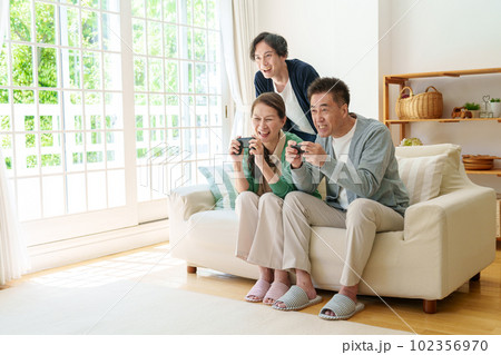 リビングでテレビゲームをプレイするシニア夫婦 リビングでテレビゲームをプレイするシニア夫婦 102356970