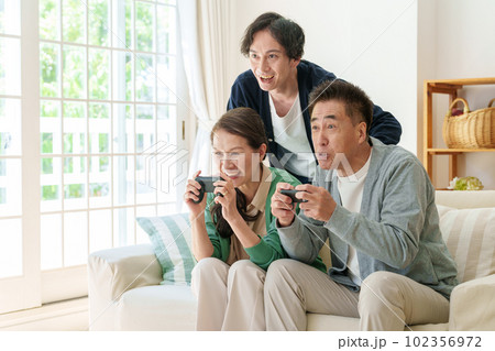 リビングでテレビゲームをプレイするシニア夫婦 102356972