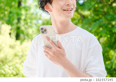 スマートフォンを使う若い男性 スマートフォンを使う若い男性 102357145
