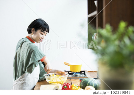 カボチャのパンケーキを作る若い女性 カボチャのパンケーキを作る若い女性 102359845