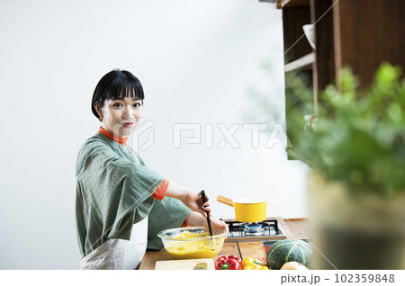 カボチャのパンケーキを作る若い女性 カボチャのパンケーキを作る若い女性 102359848