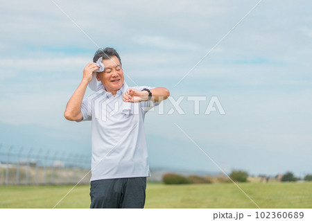 腕時計・活動量計を見ながら運動・トレーニング・ウォーキングするシニア・高齢者男性 102360689