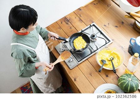 カボチャのパンケーキを作る若い女性 カボチャのパンケーキを作る若い女性 102362586