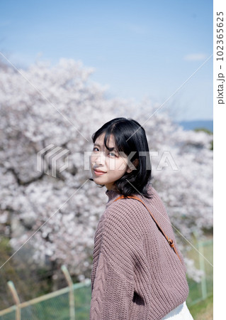 桜でお花見しながらほほ笑む女性 桜でお花見しながらほほ笑む女性 102365625
