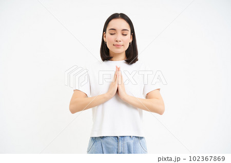 Yoga and mindfulness. Smiling relaxed asian girl, meditating, does mindful, wellness exercises, white background 102367869