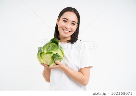 Beautiful korean woman, holding cabbage and smiling, isolated on white studio background 102368073