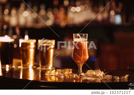 glass of unfiltered draft golden foam beer with on the bar counter glass of unfiltered draft golden foam beer with on the bar counter 102371217