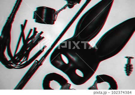 Handcuffs, whip flogger for BDSM sex with submission and domination. A set of adult intimate erotic sex toys 102374384