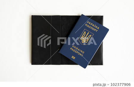 Ukrainian biometric passport id on a leather passport cover to travel the Europe without visas on the table. Inscription in Ukrainian Ukraine Passport. 102377906