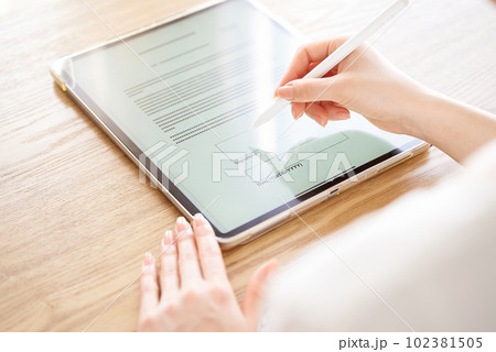 スタイラスペンで電子サインをする女性の手元 102381505