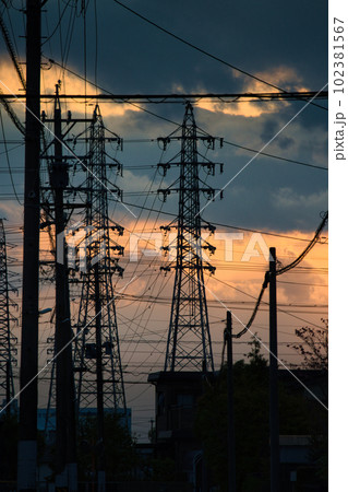 夕焼けで黄色く霞む空と建物のシルエット 102381567