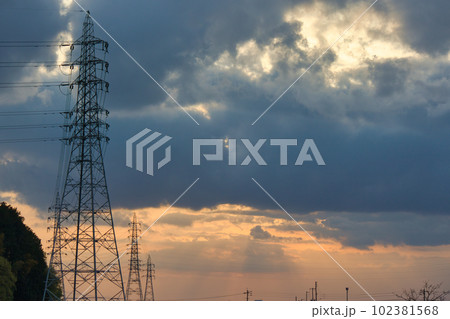 夕焼けで黄色く霞む空と建物のシルエット 102381568