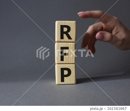 RFP - Request for Proposal. Wooden cubes with word RFP. Businessman hand. Beautiful grey background. Business and Request for Proposal concept. Copy space. RFP - Request for Proposal. Wooden cubes with word RFP. Businessman hand. Beautiful grey background. Business and Request for Proposal concept. Copy space. 102381667