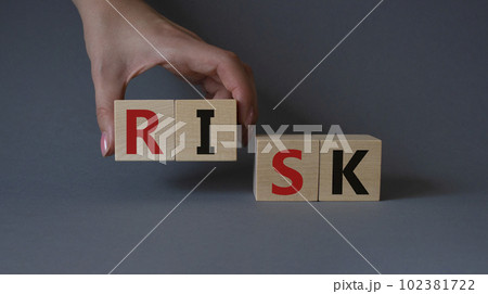 Risk symbol. Concept word Risk on wooden cubes. Businessman hand. Beautiful grey background. Business and Risk concept. Copy space. 102381722
