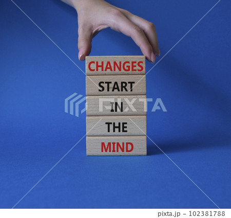 Changes start in the Mind symbol. Wooden blocks with words Changes start in the Mind. Beautiful blue background. Businessman hand. Business and Changes start in the Mind concept. Copy space. 102381788