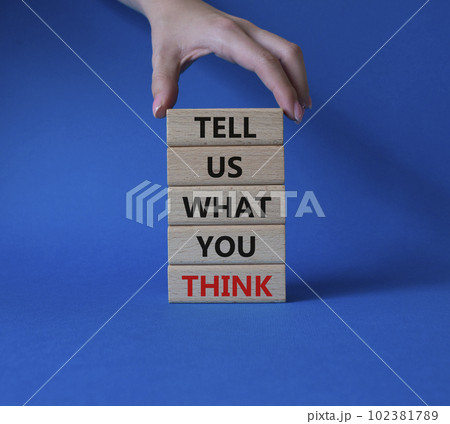 Tell us what you think symbol. Wooden blocks with words Tell us what you think. Beautiful blue background. Businessman hand. Business and Tell us what you think concept. Copy space. 102381789