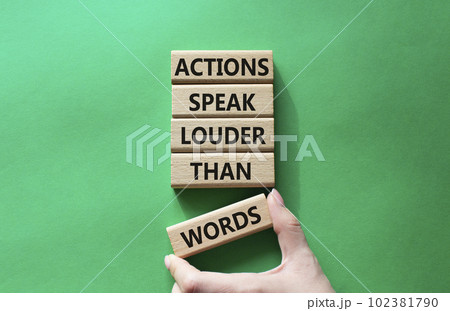 Actions speak louder than Words symbol. Wooden blocks with words Actions speak louder than Words. Beautiful green background. Businessman hand. Business and Actions concept. Copy space. 102381790