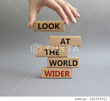 Look at the world wider symbol. Wooden blocks with words Look at the world wider. Beautiful grey background. Businessman hand. Business and Look at the world wider concept. Copy space. 102381811