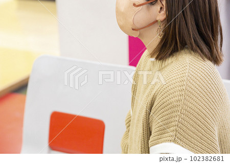 ボウリング場で座って順番待ちをする女性 102382681