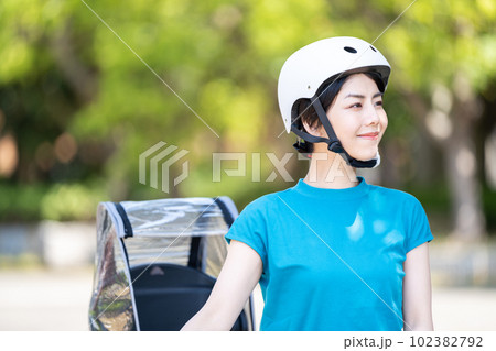 ヘルメットを被って自転車に乗る女性。 102382792