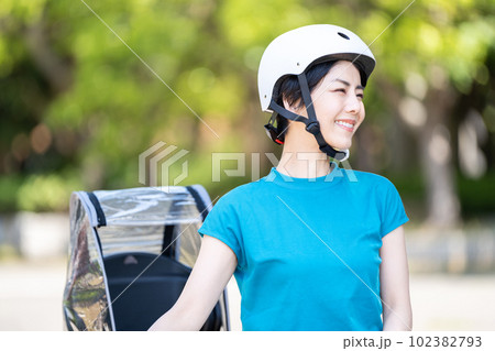 ヘルメットを被って自転車に乗る女性。 102382793