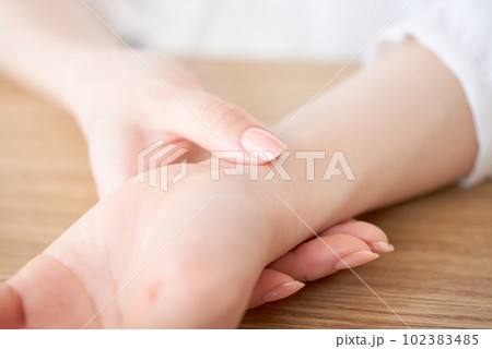 脈拍を計る女性の手元 102383485