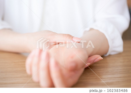 脈拍を計る女性の手元 102383486