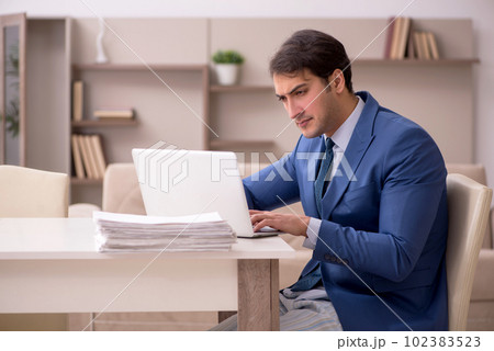 Young male employee working from home during pandemic Young male employee working from home during pandemic 102383523