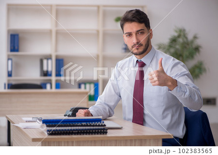 Young male employee working in the office Young male employee working in the office 102383565