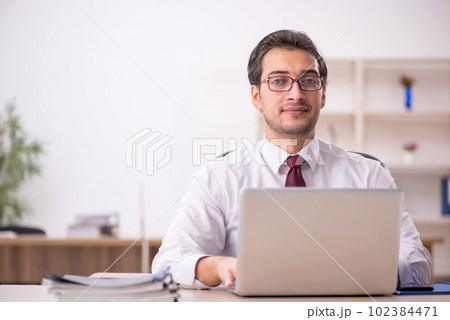 Young male employee and too much work in the office 102384471