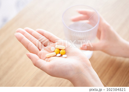 薬を持つ女性の手元 102384821