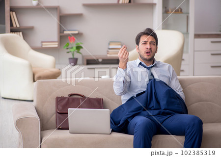 Young male employee working from home during pandemic 102385319