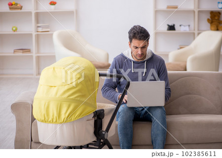 Young man looking after newborn at home 102385611