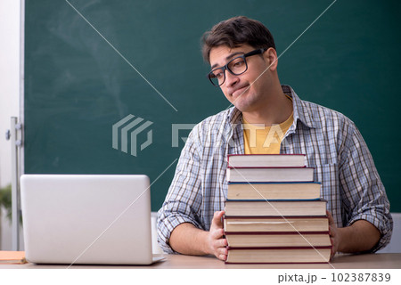 Young male student preparing for exams in the classroom 102387839