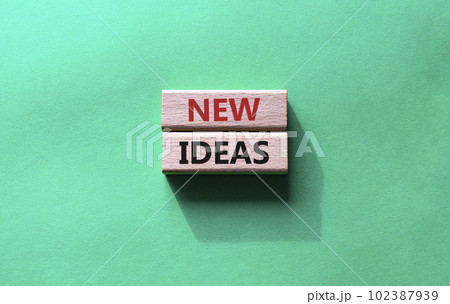 New ideas symbol. Concept word New ideas on wooden blocks. Beautiful green background. Business and New ideas concept. Copy space 102387939