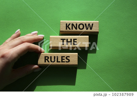 Know the rules symbol. Wooden blocks with words Know the rules. Beautiful green background. Businessman hand. Business and Know the rules concept. Copy space. 102387989
