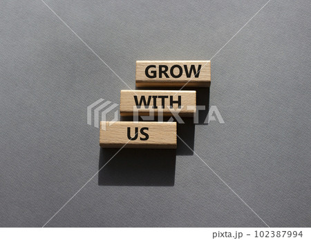 Grow with us symbol. Wooden blocks with words Grow with us. Beautiful grey background. Business and Grow with us concept. Copy space. 102387994