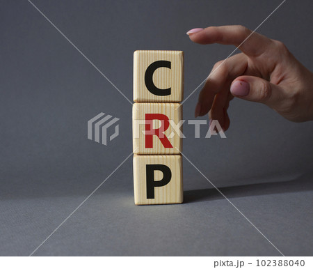 CRP - C-Reactive Protein Test symbol. Wooden cubes with word CRP. Doctor hand. Beautiful grey background. Medical and C-Reactive Protein Test concept. Copy space. 102388040