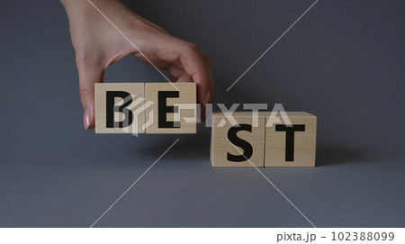 Best symbol. Concept word Best on wooden cubes. Businessman hand. Beautiful grey background. Business and Best concept. Copy space. 102388099